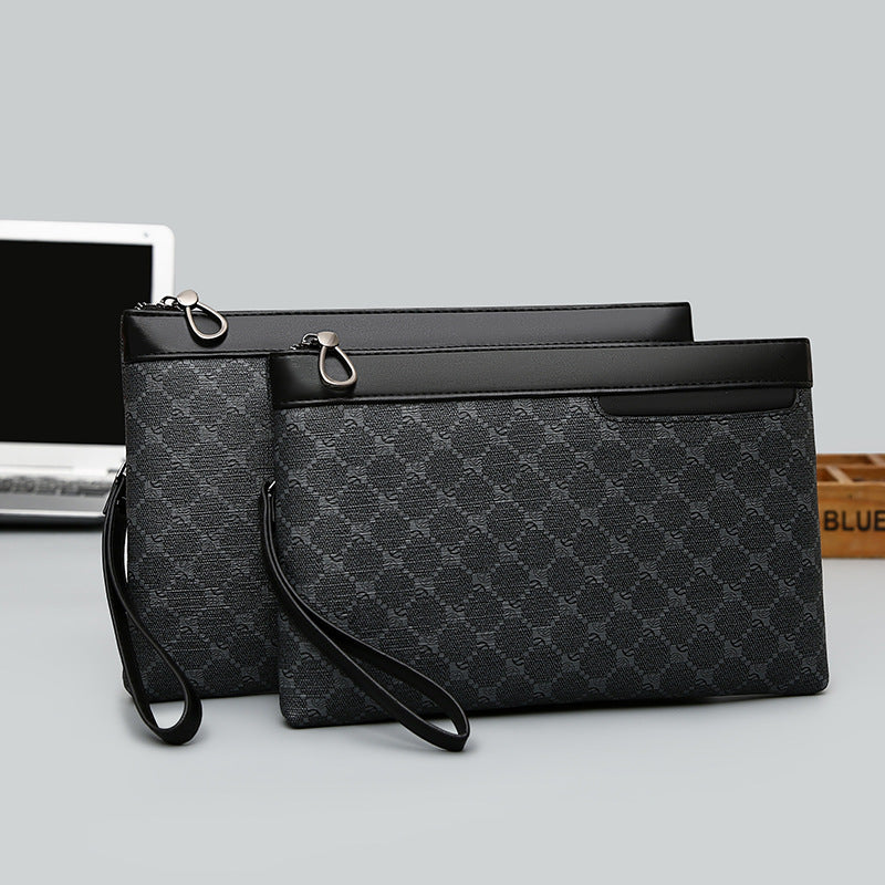 Two black patterned clutch bags on a light gray surface with a laptop in the background.